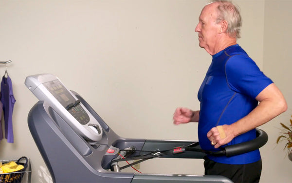 Senior man working out on a treadmill while using Treadmill Max treadmill stability belt